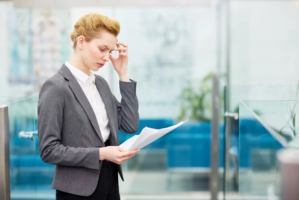 Busy female reading business papers at work